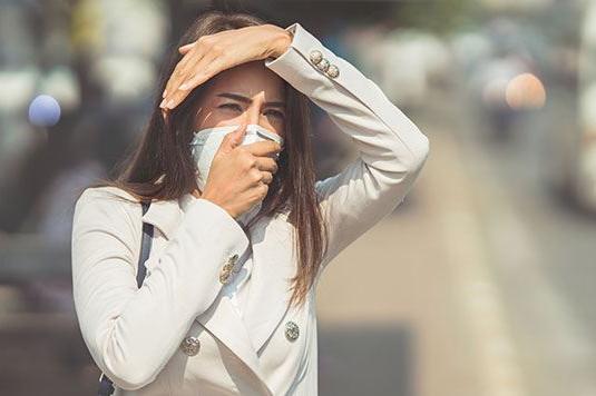 A woman with a mask on standing outside